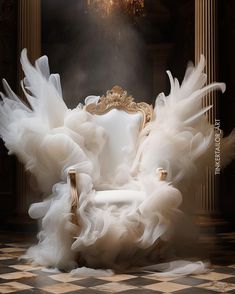 a white chair with lots of ruffled fabric on it in front of a chandelier