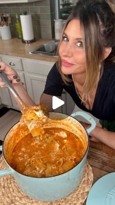 a woman is cooking in a pot on the kitchen counter with her hands holding a ladle