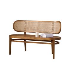 a wooden bench with wicker back rest and cup on the table next to it