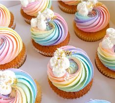 cupcakes decorated with rainbow icing and white flowers