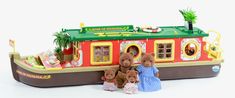 three teddy bears are standing in front of a toy boat with people on the deck