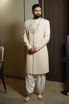 Cream full sleeves lucknowi sherwani with all over floral motif embroidery and band collar neckline. Paired with a 6 layered mala.
Components: 2
Pattern: Embroidery
Type Of Work: Floral
Neckline: Band Collar
Sleeve Type: Full
Fabric: Lucknowi
Color: Cream
Other Details: 
Note: The salwar worn by the model is not for sale
Occasion: Groom, Wedding - Aza Fashions Long Sleeve Kurta With Naqshi For Reception, Long Sleeve Sherwani For Diwali Reception, Long Sleeve Sherwani With Cutdana For Reception, Reception Sherwani With Cutdana And Long Sleeves, Traditional Long Sleeve Sherwani With Cutdana, Naqshi Kurta For Eid Reception, Naqshi Embellished Kurta For Reception And Eid, Eid Kurta With Naqshi For Reception, Eid Reception Kurta With Naqshi