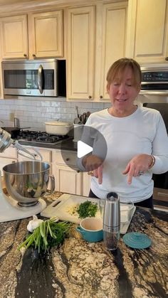 a woman standing in a kitchen preparing food