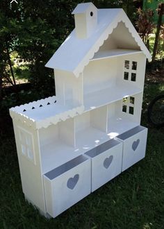 a doll house made out of cardboard sitting in the grass