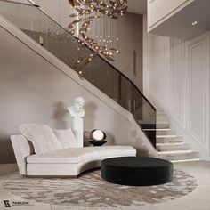 a white couch sitting under a chandelier next to a stair case