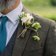 a man wearing a suit and tie with a boutonniere on his lapel