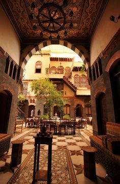 the inside of an old building with tables and chairs in it's courtyard area