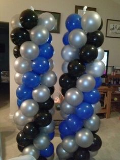 two tall blue and black balloons in the shape of letters