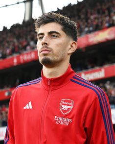 a soccer player is standing in front of the stands at an empty stadium with his eyes closed