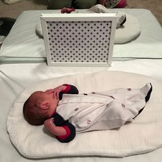 a baby laying on top of a white blanket