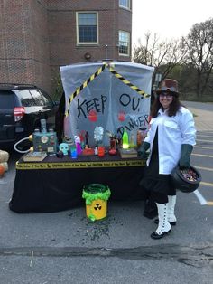 a woman standing in front of a table with items on it