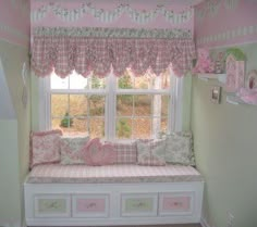 a pink and white room with a window seat