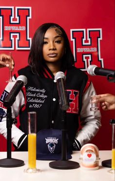 a woman standing in front of microphones at a table