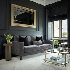 a living room with black walls and furniture