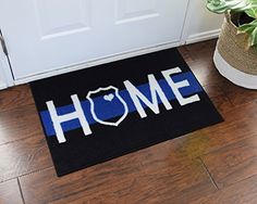 a blue and black door mat with the word home on it next to a potted plant