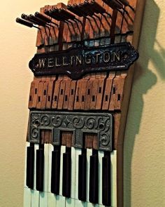 a wooden sign that says wellington on top of an old piano keys and trellis