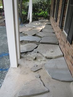 a stone walkway that has been laid in front of a house