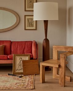 a living room filled with furniture next to a lamp and pictures hanging on the wall