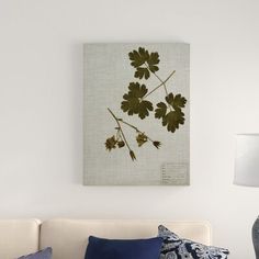 a living room with a white couch, blue pillows and a painting on the wall