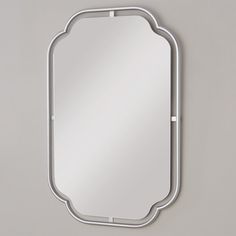 a mirror that is on the wall with a metal frame and an arch around it