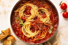 a pan filled with spaghetti and sauce on top of a table