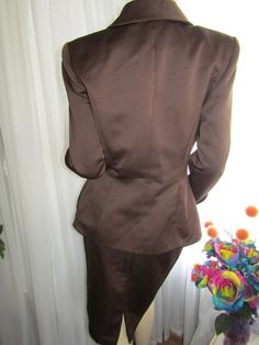 "Classy ladies 80's brown 2-piece cocktail suit, with shoulder pads, sleeve cuffs, and elastic waist in skirt back/zipper. Jacket has a gathered side waist that gives you a fitted waist fit, with 1\" round metal buttons down the front filled with brown rhinestones. These buttons are sewn to jacket and appears with fake button holes to be it's closure, but the inside of jacket under the rhinestone buttons, is actually closed with clear plastic inside buttons. The skirt has a back bottom split. Th Cocktail Suit, Opera Coat, Womens Suits, Button Holes, Button Jacket, Zipper Jacket, Classy Women, Jacket Buttons, Metal Buttons