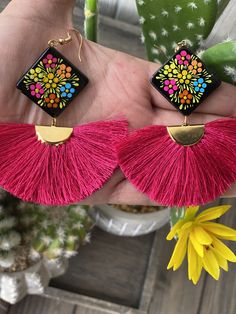 These beautiful earrings are hand painted on wood with a silk thread fan. It is the perfect accessory and pop of color for your outfit! Every piece is completely unique because of the detailed process that goes into creating it. The black lacquer is created by mixing in layers of dirt with a grease from the Cochinilla bug. The flowers are painted on with our finger tips using ground up natural pigments and linseed oil. To finish the process we apply a protective coat to conserve the painting and Multicolor Tassel Earrings For Gifts, Unique Multicolor Tassel Earrings For Gift, Colorful Tassel Earrings As A Gift, Colorful Tassel Earrings For Gift, Tassel Earrings As A Gift, Diy Earrings Easy, Mexican Earrings, Natural Pigments, Finger Tips