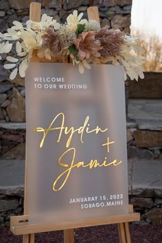 a sign with flowers on it that reads, welcome to our wedding and the date