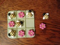 there are many small cakes made to look like flowers and bee's on squares