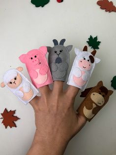 four finger puppets are held in the palm of someone's hand