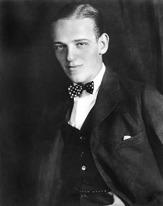 an old photo of a man wearing a suit and bow tie