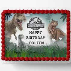 a birthday cake with two dinosaurs on the front and one dinosaur on the back in red icing