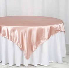 a round table with a pink satin overlay