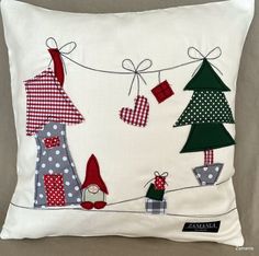 a white pillow with christmas decorations hanging from it