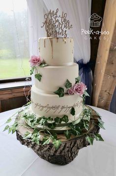 a three tiered wedding cake with greenery on top