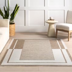 a living room with a rug, chair and potted plant