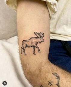 a man with a tattoo on his arm that has a moose and arrows drawn on it