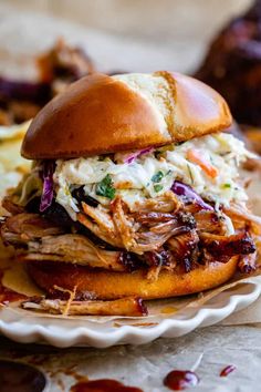 a pulled pork sandwich with cole slaw on a plate