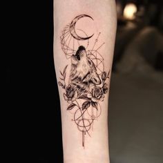 a black and white tattoo with a wolf on it's arm, surrounded by roses