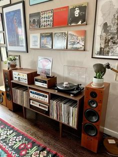 there is a record player in the corner of this room with many pictures on the wall