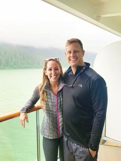 a man and woman standing next to each other on a boat