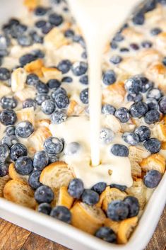 blueberry french toast casserole being drizzled with icing on a wooden table