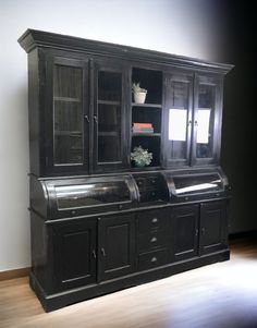 an old black china cabinet with glass doors