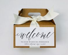 an open box with a welcome sign on it and a ribbon tied around the top