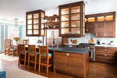 a large kitchen with wooden cabinets and blue chairs in it's center island area