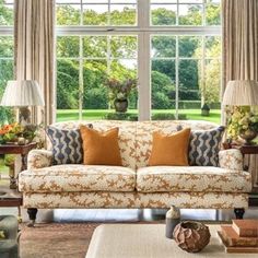 a living room filled with furniture and large windows