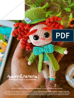 a crocheted doll with red hair and green clothes