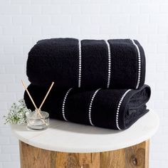 two black towels sitting on top of a wooden table