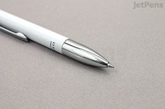 a silver pen sitting on top of a table