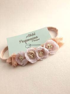 the headband has three flowers on it and is attached to a card with a name tag